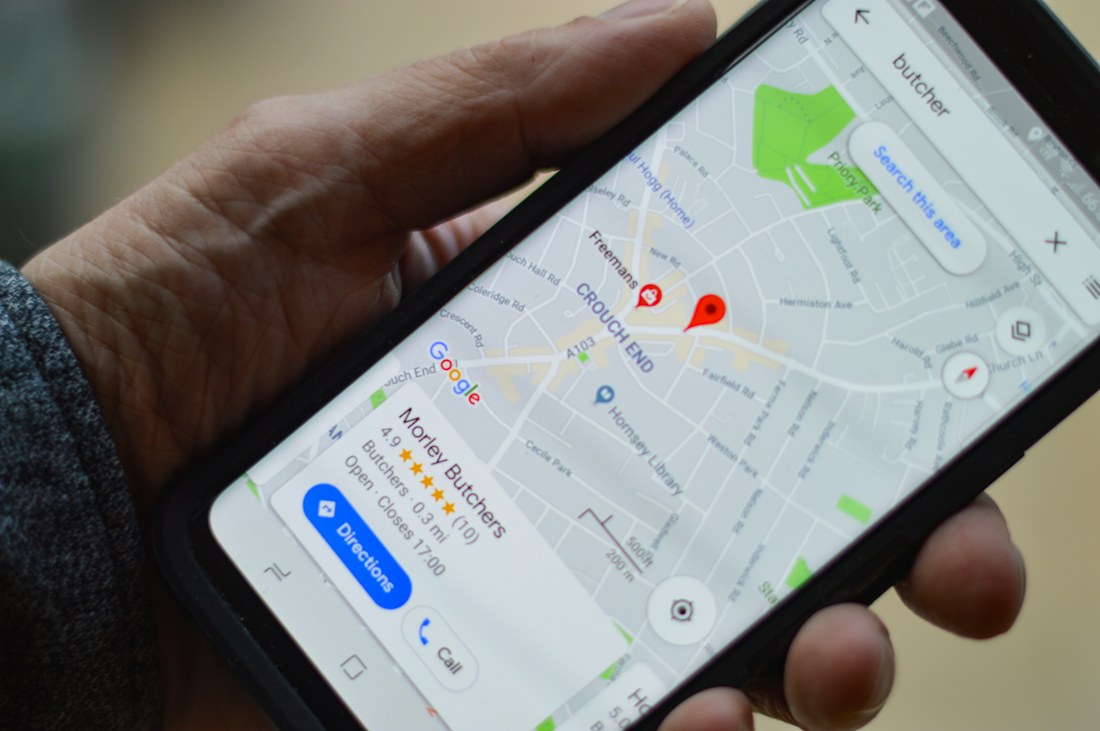 A person holding a smartphone with a map on screen