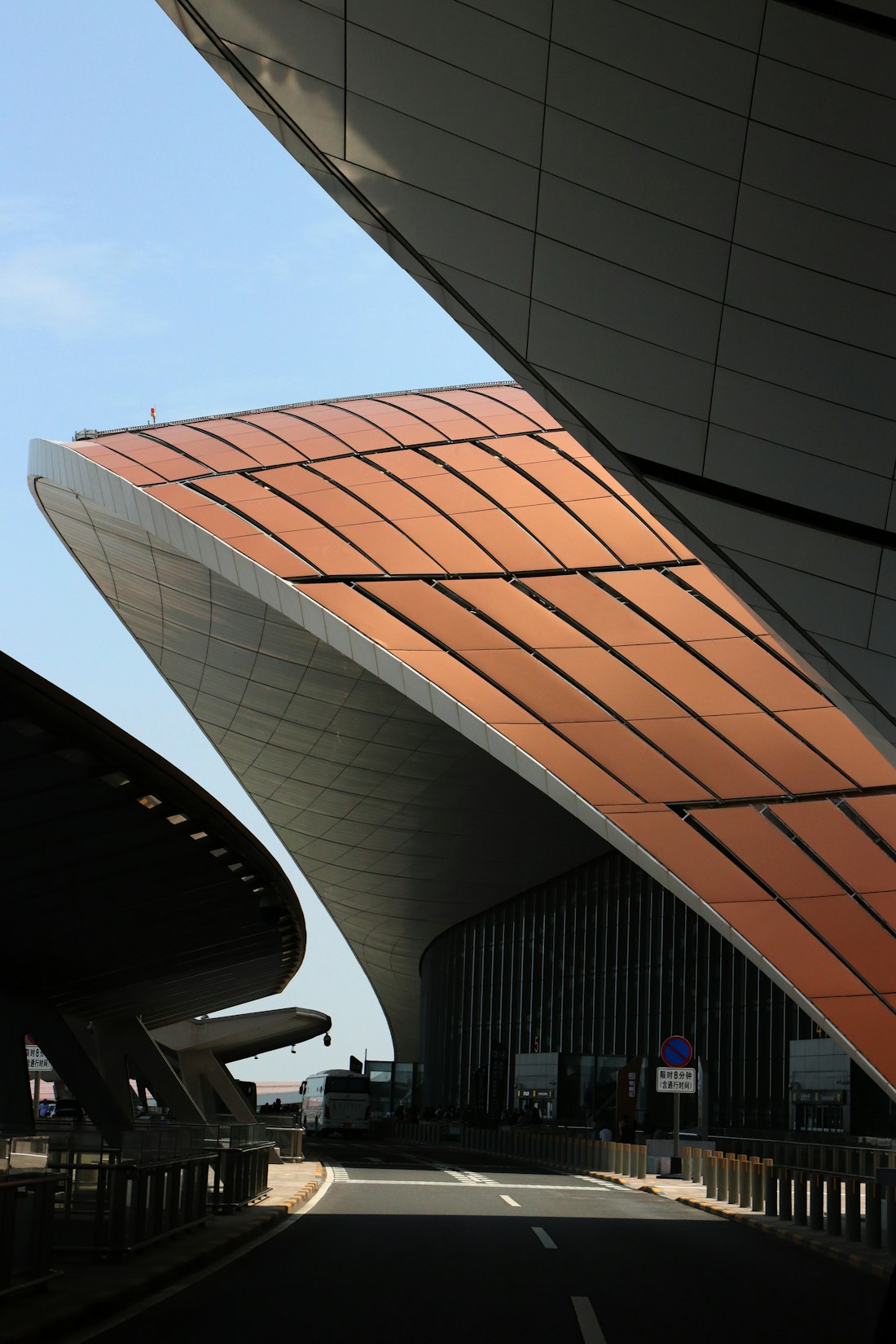 The curved terminal roof and access road at Beijing Daxing International Airport